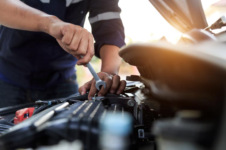 Bilmekanikerreparatör händer som reparerar en bilmotorverkstad med en skiftnyckel, bilservice och underhåll